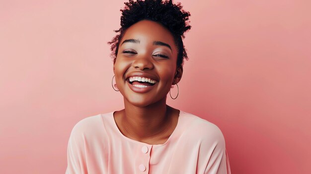 Bela jovem afro-americana com cabelos encaracolados rindo felizmente contra um fundo rosa