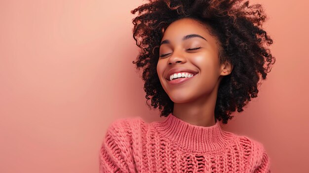 Bela jovem afro-americana com cabelos encaracolados sorrindo e rindo ela está vestindo uma camisola rosa