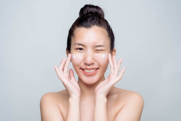 Bela jovem asiática com pele limpa, fresca, sobre fundo branco. Retrato de mulheres asiáticas.