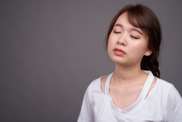 Bela jovem asiática relaxando com os olhos fechados