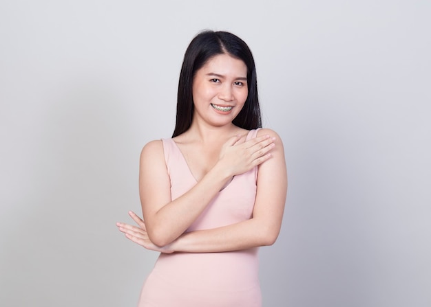 Bela jovem asiática sorrindo retrato de uma garota com vestido rosa se divertir e feliz de positivo com sucesso isolado no fundo branco