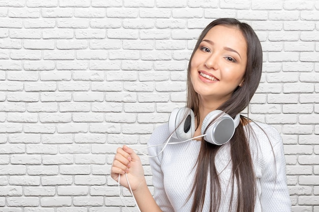 Bela jovem asiática usando um conjunto de fones de ouvido