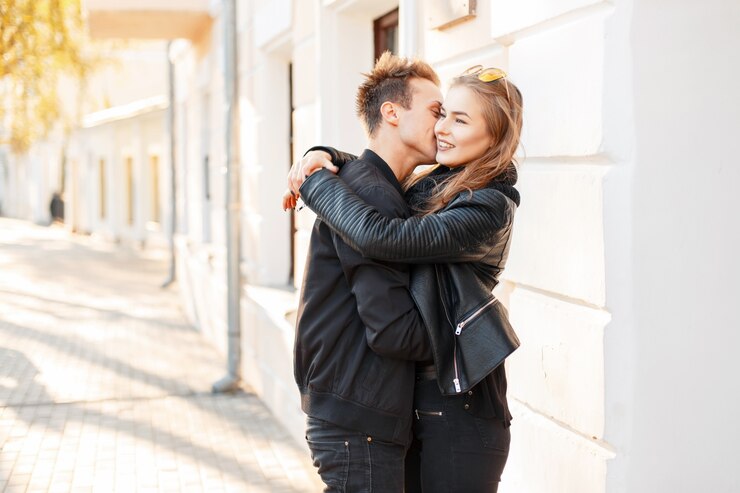 Foto bela jovem casal feliz se beijando na cidade em um dia ensolarado