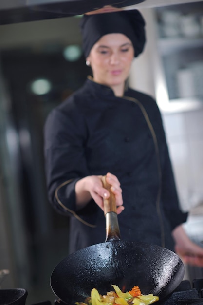 bela jovem chef preparar e decorar comida saborosa na cozinha