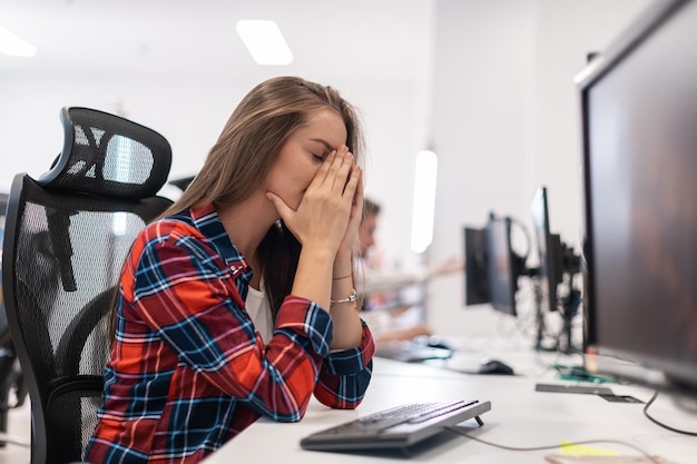 Bela jovem chocada e irritada olhando para seu desktop. Mulher de agente de operador triste trabalhando em casa em um call center. Foto de alta qualidade