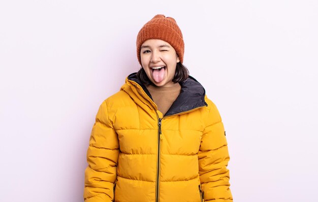 Bela jovem com atitude alegre e rebelde, brincando e mostrando a língua. conceito de clima frio