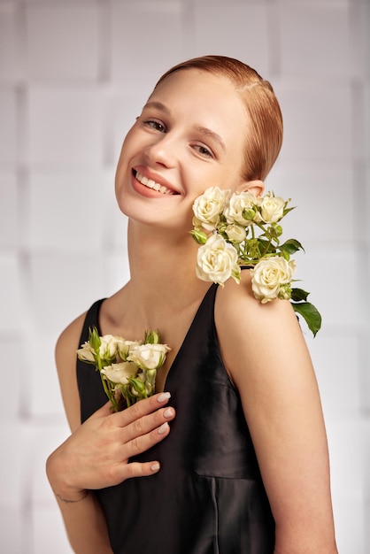 Bela jovem com necessidades especiais mulher com flores na mão sorri alegremente segurando uma flor