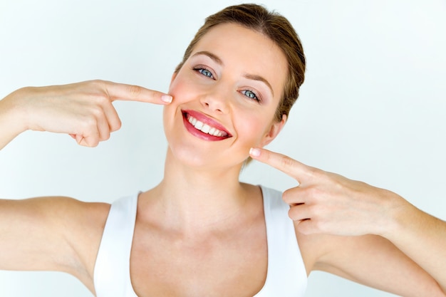 Bela jovem com sorriso perfeito. isolado no branco.