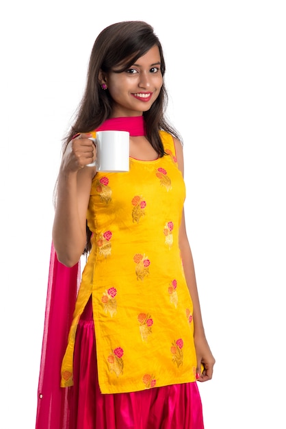 Bela jovem com uma xícara de chá ou café posando em branco