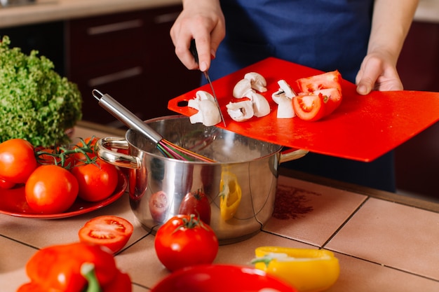 Bela jovem cozinhar comida em casa