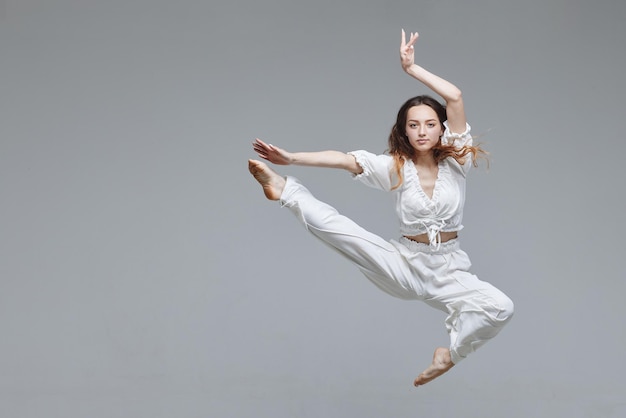 Bela jovem dançarina moderna ou dançarina de fitness em um fundo branco isolado