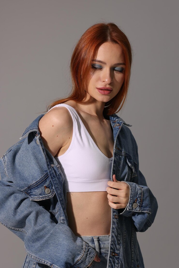 Foto bela jovem de jaqueta de jeans em fundo cinza