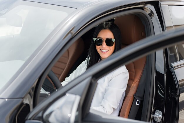 Bela jovem dentro de um carro de luxo