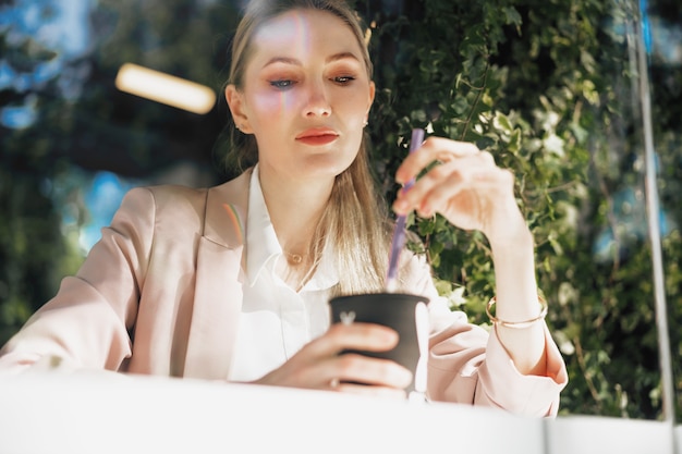 Bela jovem empresária tomando café em uma cafeteria ao ar livre