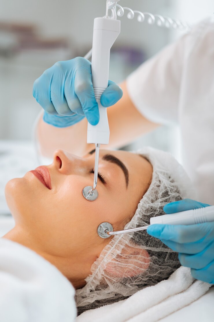 Foto bela jovem fechando os olhos durante uma sessão de terapia por microcorrente
