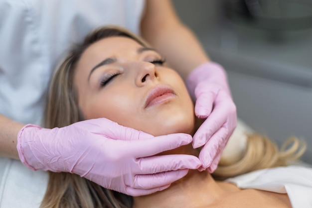 Bela jovem modelo de mulher fresca encontra-se em procedimentos em um cosmetologista em uma clínica de beleza cuidado facial