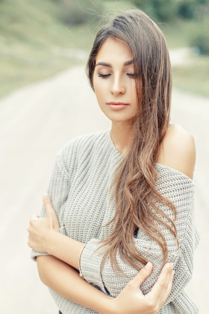 Bela jovem modelo feminino com o penteado em um agasalho de malha quente