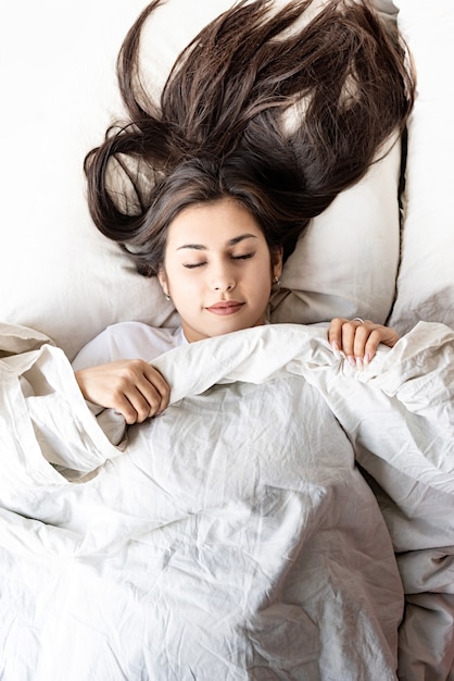 Bela jovem morena dormindo na cama