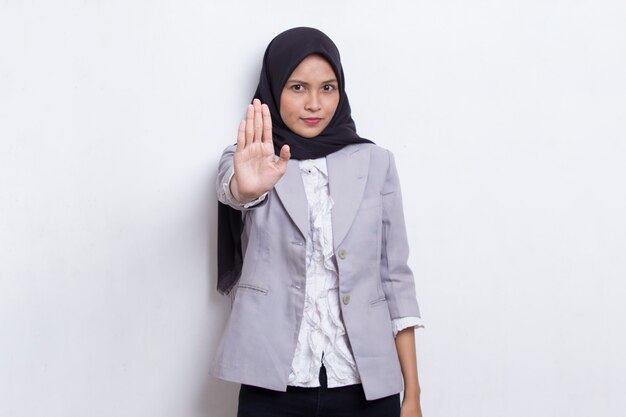 Bela jovem muçulmana com a mão aberta fazendo um sinal de pare com um gesto sério de defesa de expressão