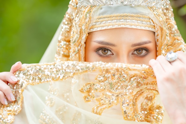 Bela jovem muçulmana com hijab dourado