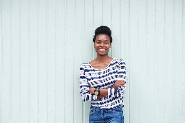 Bela jovem negra sorrindo com braços cruzados