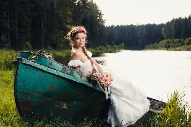 Bela jovem noiva sentada no barco