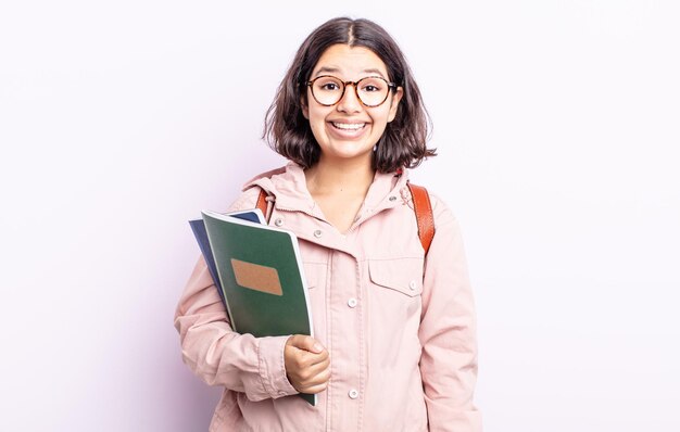 Bela jovem parecendo feliz e agradavelmente surpresa. estudante com conceito de livros