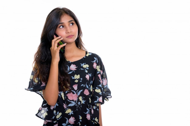 bela jovem persa pensando enquanto fala ao telefone