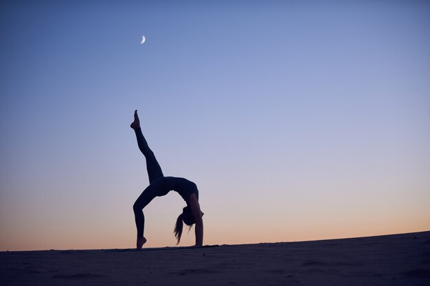 Bela jovem pratica backbend yoga asana Eka Pada Urdhva Dhanurasana