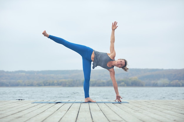 Bela jovem pratica ioga asana Ardha Chandrasana