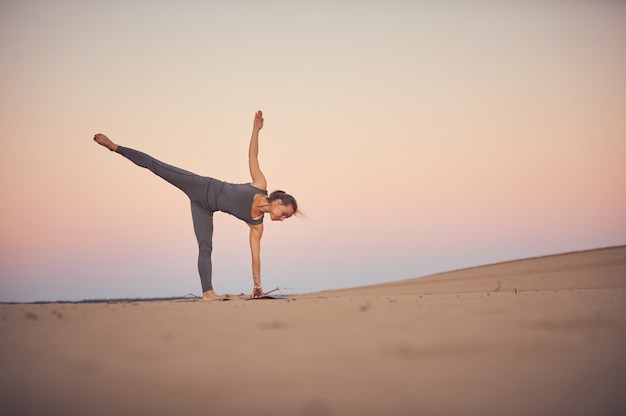 Bela jovem pratica ioga asana ardha chandrasana