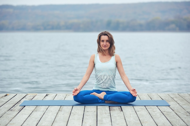 Bela jovem pratica ioga asana Padmasana