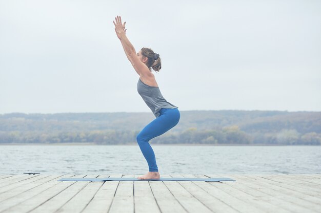 Bela jovem pratica ioga asana Utkatasana