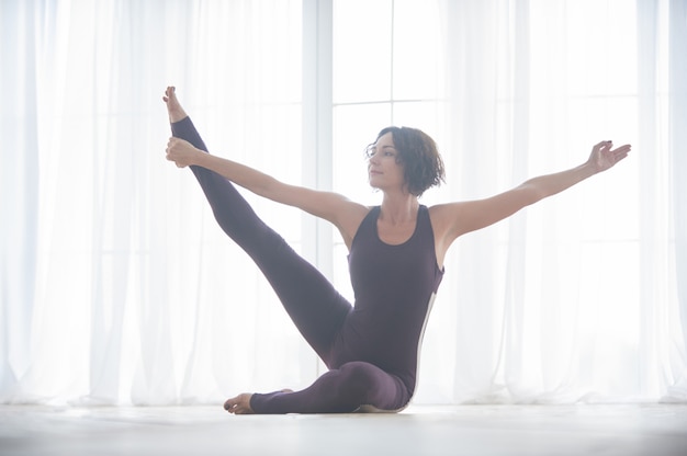 Bela jovem pratica yoga asana no estúdio de yoga luz