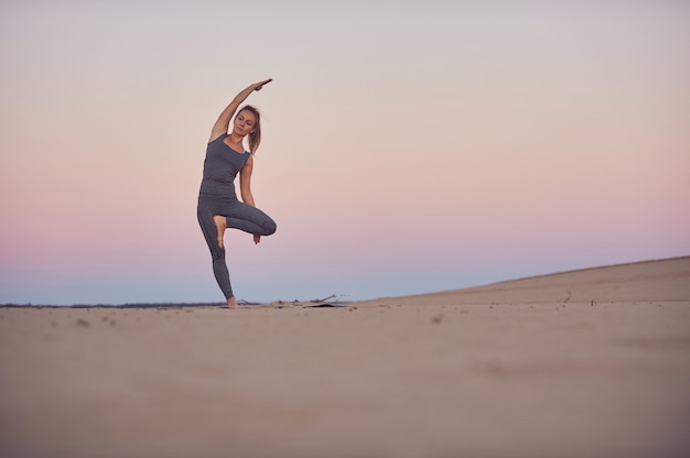 Bela jovem pratica yoga asana Parshva Vrikshasana