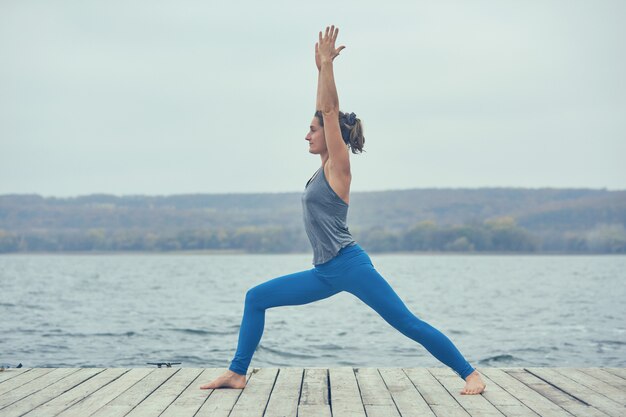 Bela jovem pratica yoga asana Virabhadrasana