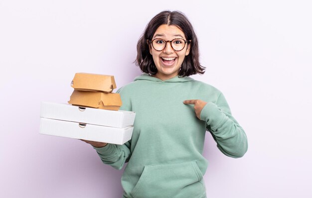 Bela jovem se sentindo feliz e apontando para si mesma com um animado. conceito de fast food take away