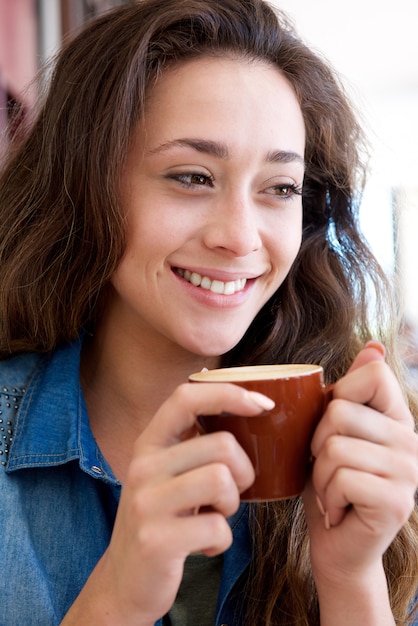 Bela jovem segurando a xícara de café