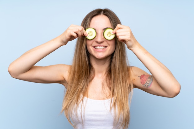 Bela jovem segurando fatias de pepino