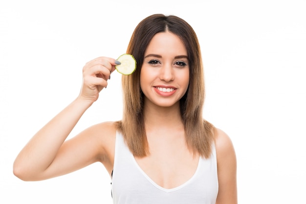 Bela jovem segurando fatias de pepino