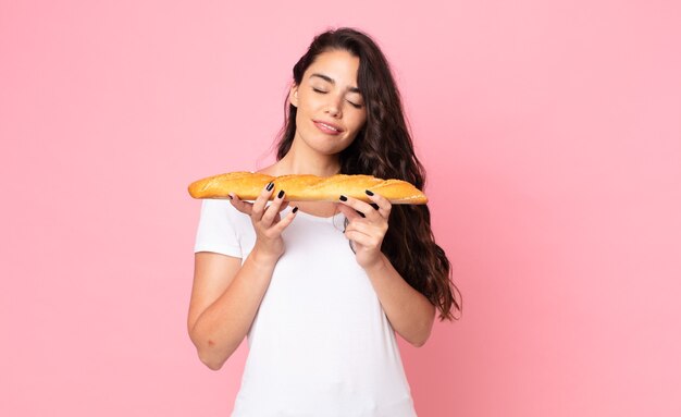 Bela jovem segurando uma baguete de pão