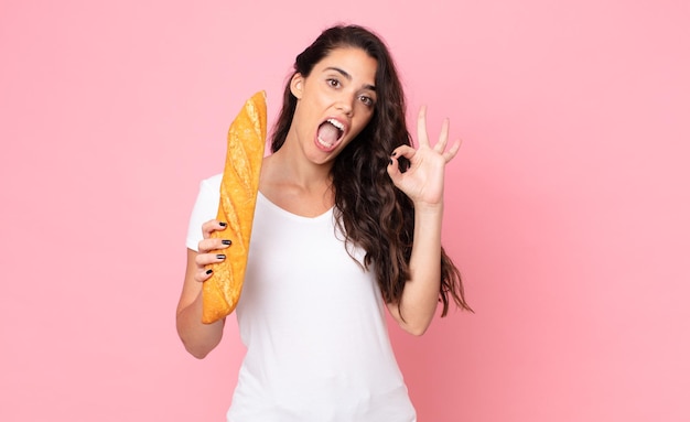 Foto bela jovem segurando uma baguete de pão