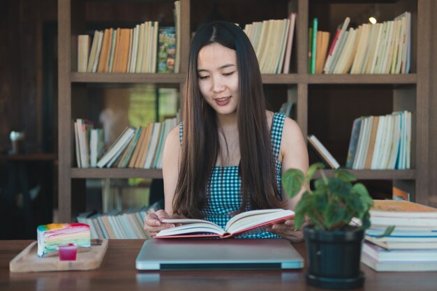 Foto bela jovem sentada e lendo o livro