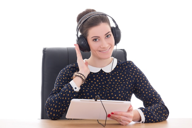 Foto bela jovem sentada no escritório ouvindo música no tablet pc isolado no fundo branco