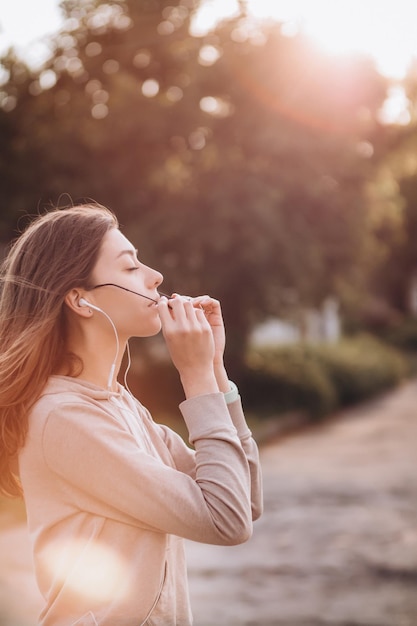 Foto bela jovem sorridente coloca óculos de sol no parque