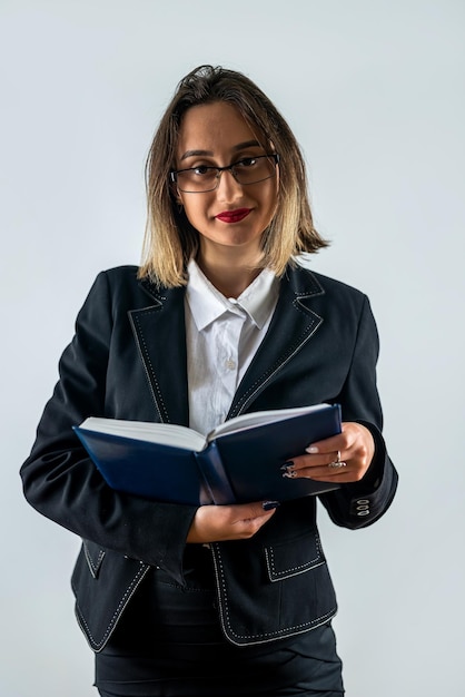 Bela jovem sorridente professora segurando papéis e livros na mão isolado