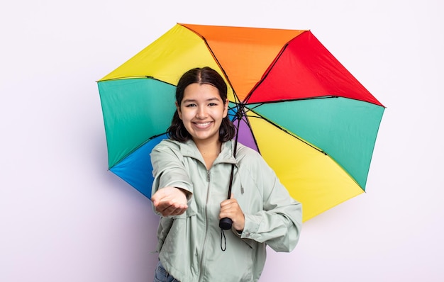 Bela jovem sorrindo feliz com amigável e oferecendo e mostrando um conceito. conceito de chuva e guarda-chuva