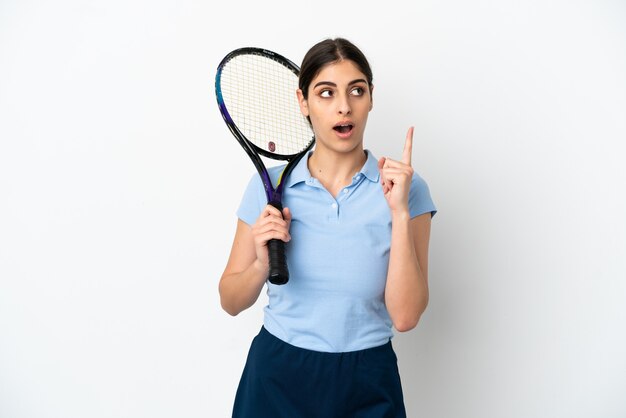 Bela jovem tenista caucasiana isolada no fundo branco, pensando em uma ideia apontando o dedo para cima