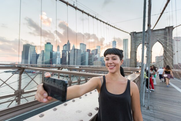 Bela jovem tomando Selfie na ponte de Brooklyn