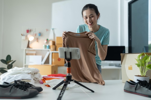 Bela jovem trabalhando na loja online vestindo roupas casuais